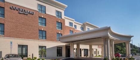 A Courtyard Marriott hotel entrance with a covered driveway, a parking area, and a handicap-accessible parking space.
