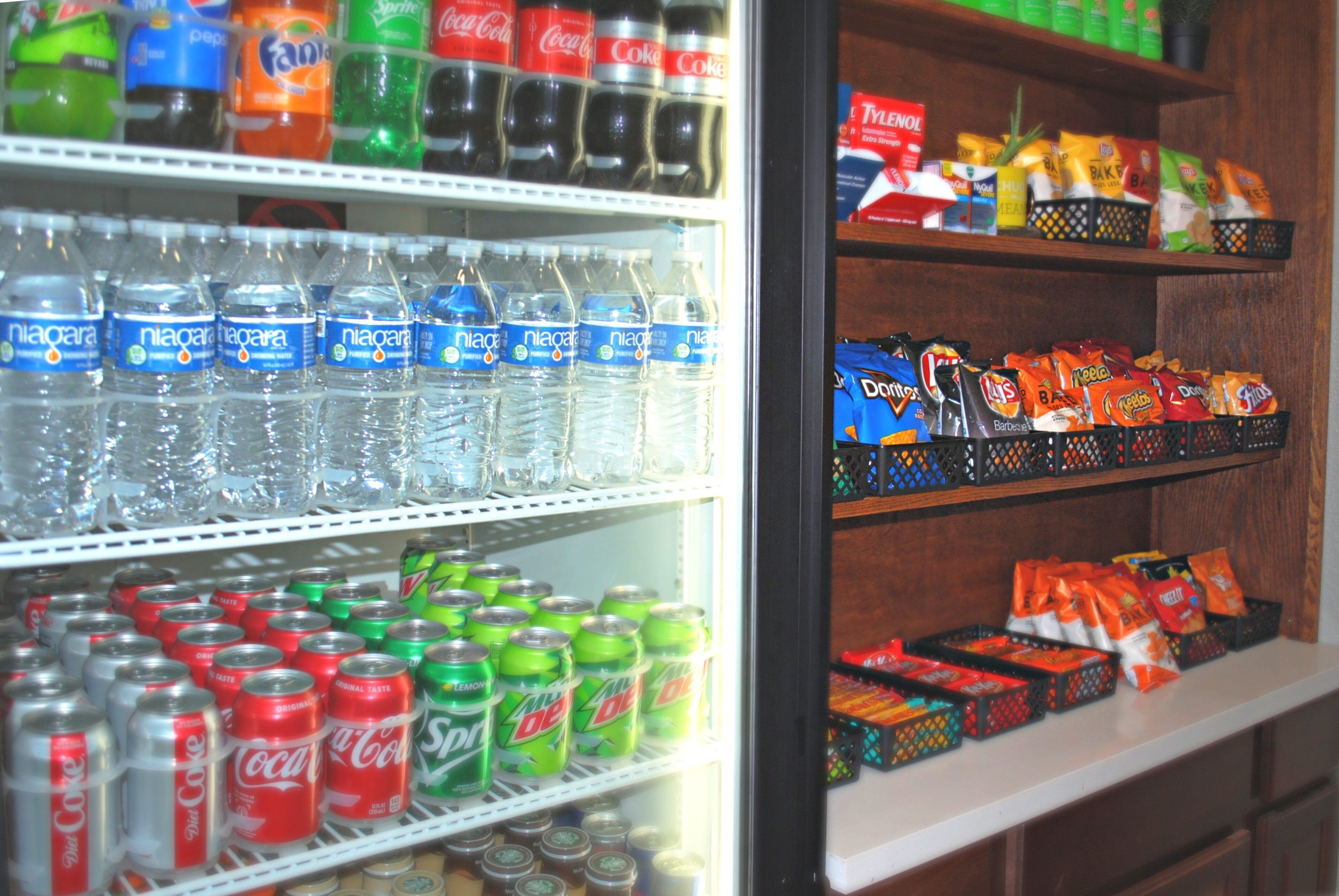 Un expositor refrigerado con diversas bebidas y aperitivos.
