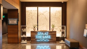 Una zona de recepción con un letrero para la piscina y un anuncio de neón para el spa.