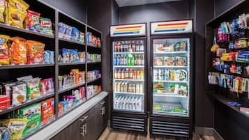 A snack and beverage section with shelves stocked with various snacks and drinks, and two refrigerated display cases.