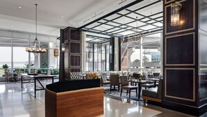 Un hall d’entrée spacieux, doté d’un comptoir d’accueil moderne, de sièges confortables et de grandes fenêtres offrant une vue sur la ville.