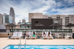 Una piscina al aire libre de temporada, sombrillas