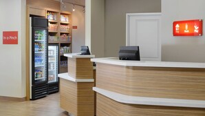 A reception area with a wooden counter, a refrigerator stocked with beverages, and a sign indicating 'In a Pinch' and 'Stay, Work, Play'. - TownePlace Suites by Marriott Denver South/Lone Tree (Lone Tree)