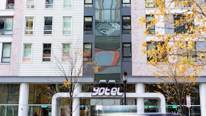 A multi-story building with a modern facade, large windows, and a visible storefront with signage. - YOTEL Boston, Select by Hilton (Boston)