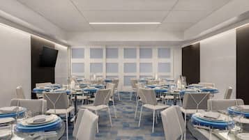 Una sala conferenze con diversi tavoli apparecchiati per la cena, completa di sedie e stoviglie.