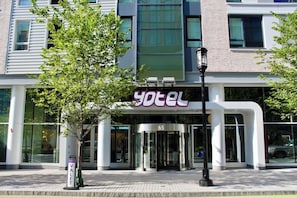 A hotel entrance with a glass door, a sign reading 'yotel', and a number '65' above the door.