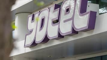 A hotel entrance with a prominent 'yotel' sign and a revolving door marked with the number '65'.