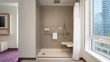 Un baño moderno con ducha, inodoro y ventana.