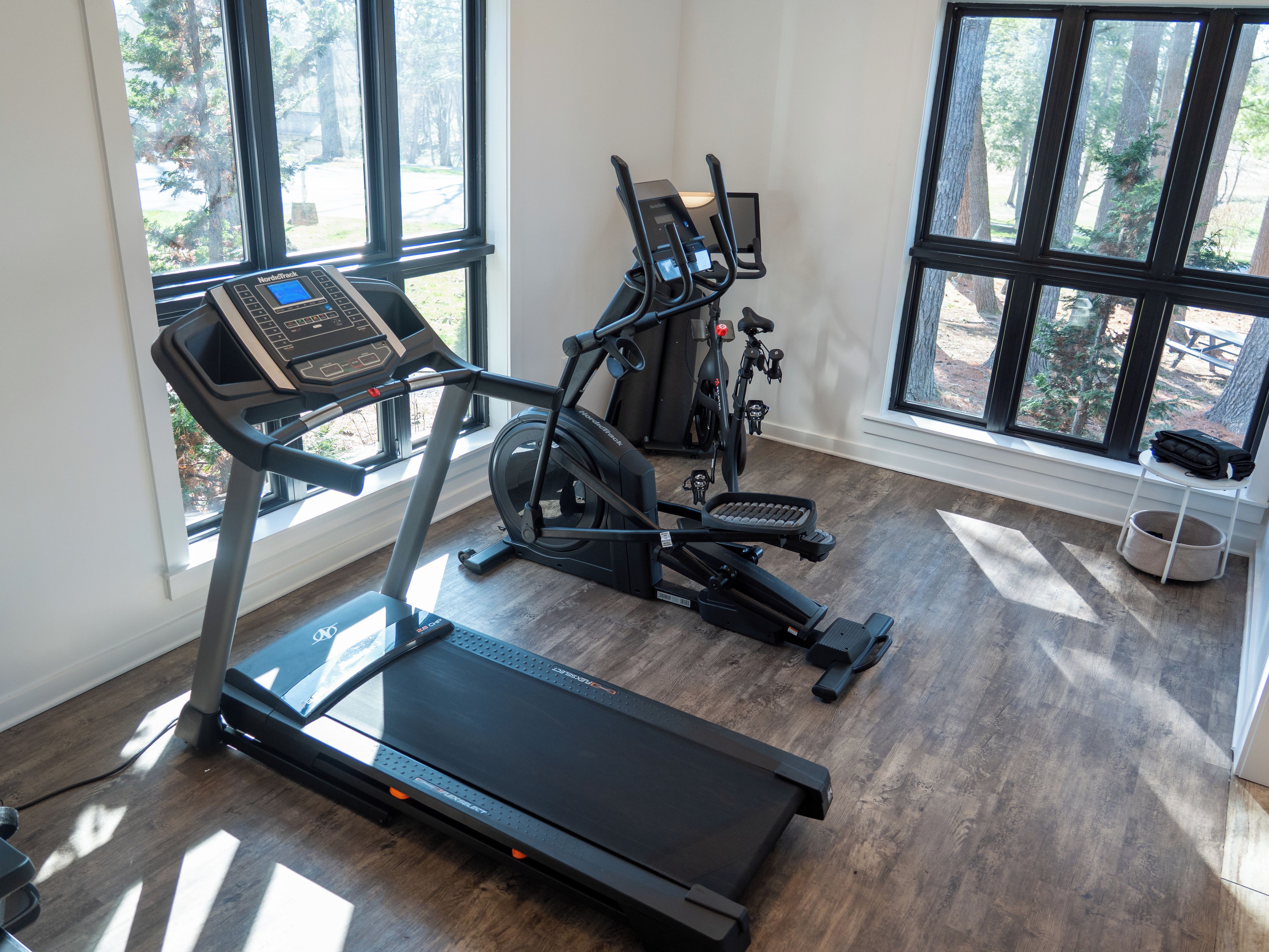 A home gym with a treadmill, stationary bikes, and exercise equipment.