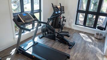 A home gym with a treadmill, stationary bikes, and exercise equipment.