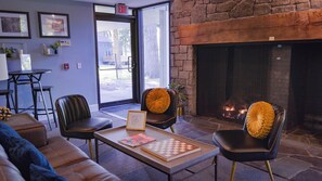 A cozy lounge area with leather sofas, a coffee table with books, and a fireplace. - Allenberry Resort (Boiling Springs)