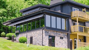 A modern two-story house with large windows, stone facade, and a wooden balcony. - Allenberry Resort (Boiling Springs)