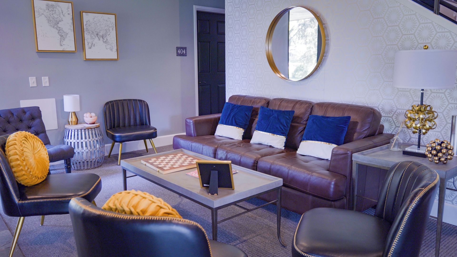 Un salon moderne avec un canapé, des fauteuils, une table basse et un jeu d’échecs.