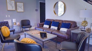 A modern living room with a sofa, armchairs, a coffee table, and a chessboard. - Allenberry Resort (Boiling Springs)