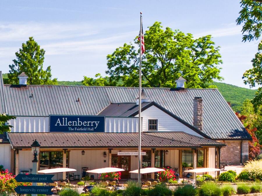 A building with a sign reading 'Allenberry The Fairfield Hall' and a flagpole with an American flag.