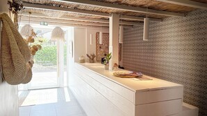 Ein moderner Hotel-Empfangsbereich mit weißem Empfangstresen, hängenden Pendelleuchten und dekorativer Wandtapete.