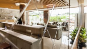 Un interior moderno con techo de madera, una zona de estar y vistas a la vegetación exterior.