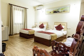 Une chambre d’hôtel avec deux lits, un plancher en bois, un bureau et une chaise.
