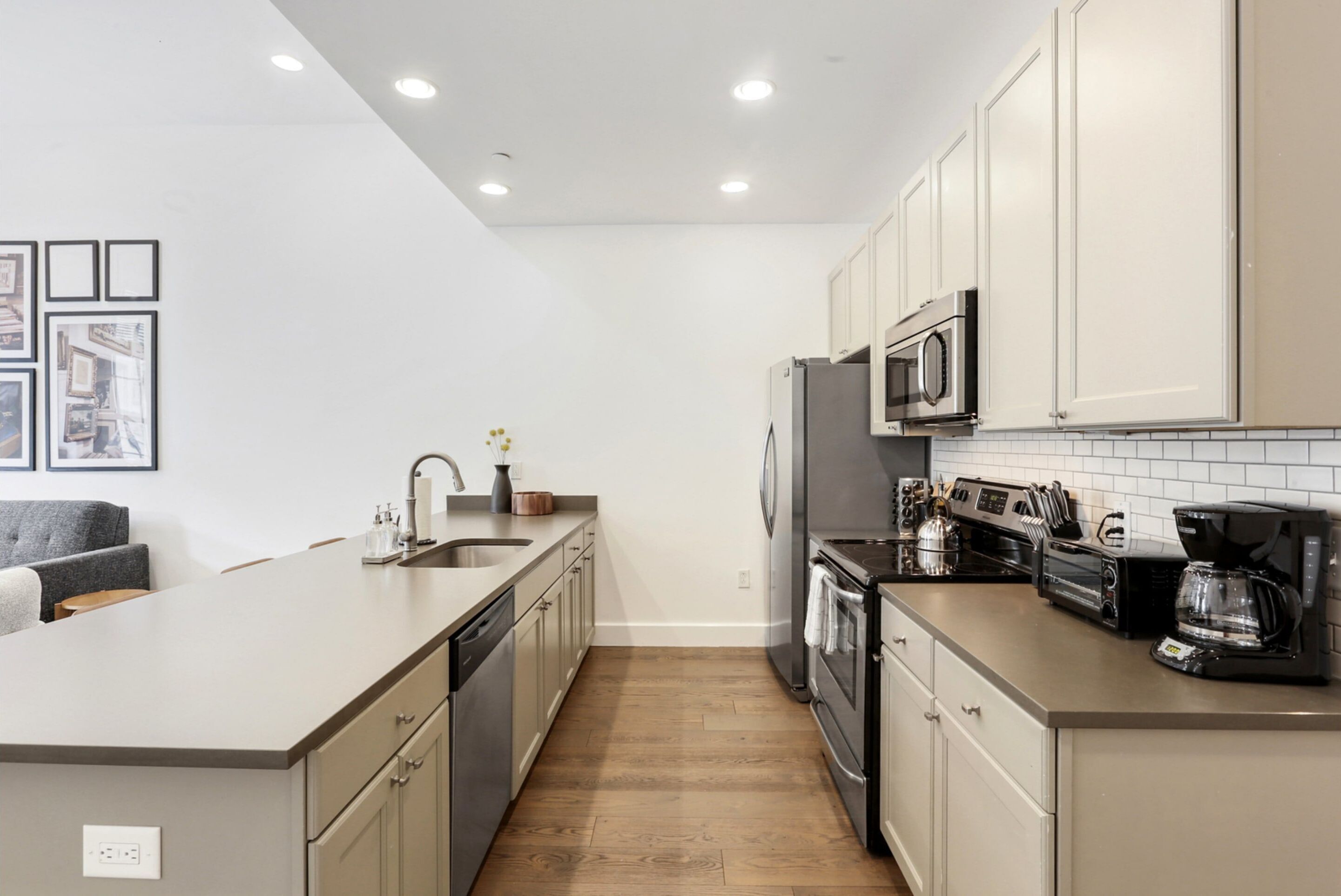 A modern kitchen with a central island, stainless steel appliances, and a tiled backsplash.
