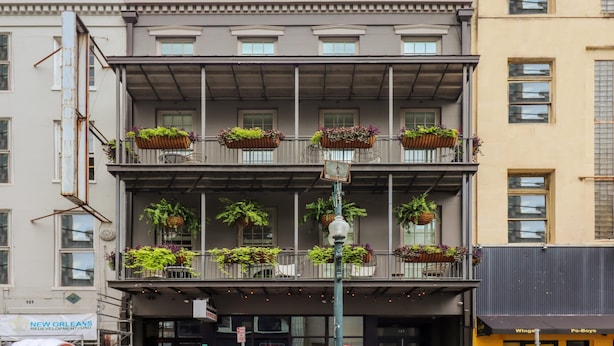 Un edificio a più piani con balconi decorati con piante in vaso.