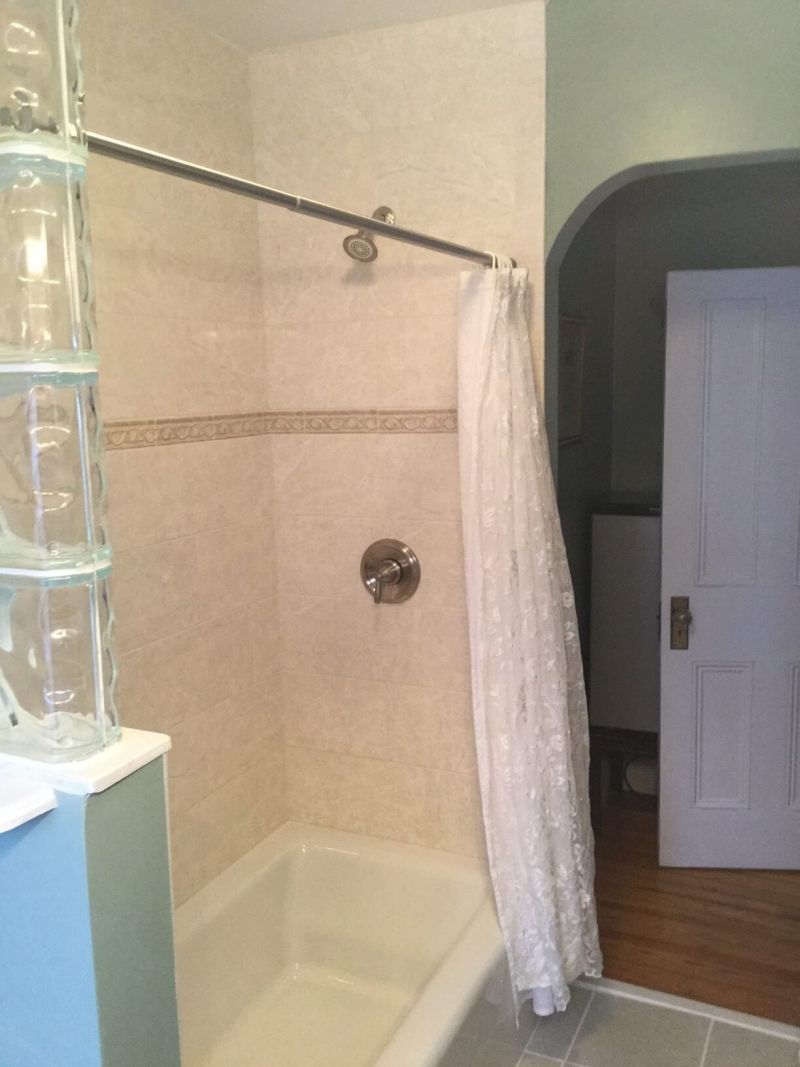 Ein Duschbereich mit Glasabtrennung, einer Duschvorhang und einer Badewanne.