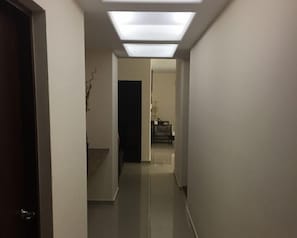 A narrow hallway with a ceiling light fixture and a door on the left. - Pacifika Marina Mazatlán (Mazatlán)