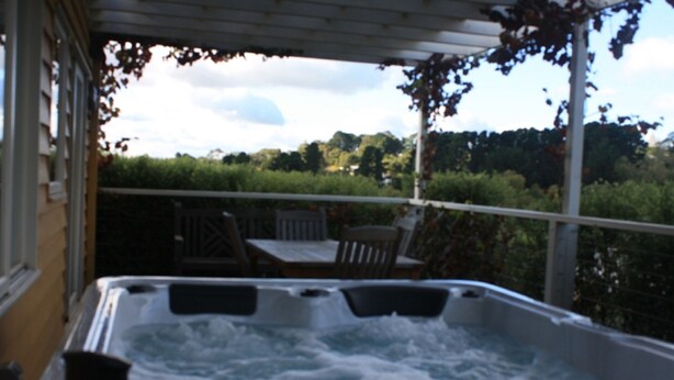 A hot tub with a view of a garden and trees. - Marzden Cottage (Daylesford)