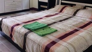 Un dormitorio con cama, armario, escritorio y espejo.