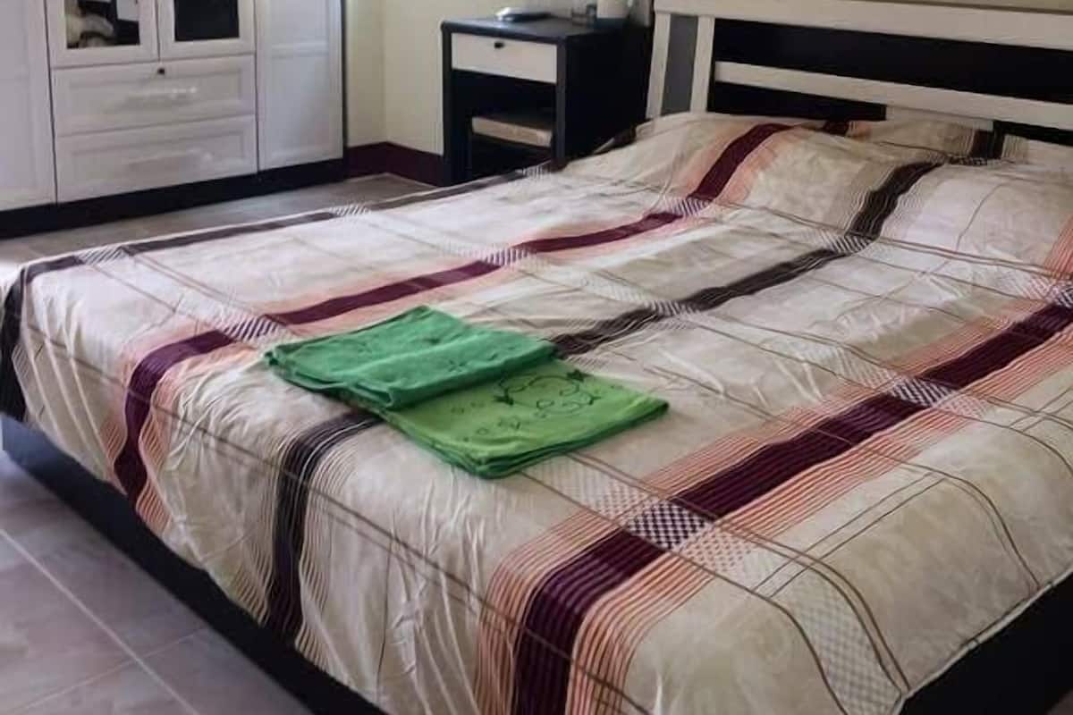 Een slaapkamer met een bed, een kledingkast, een bureau en een spiegel.