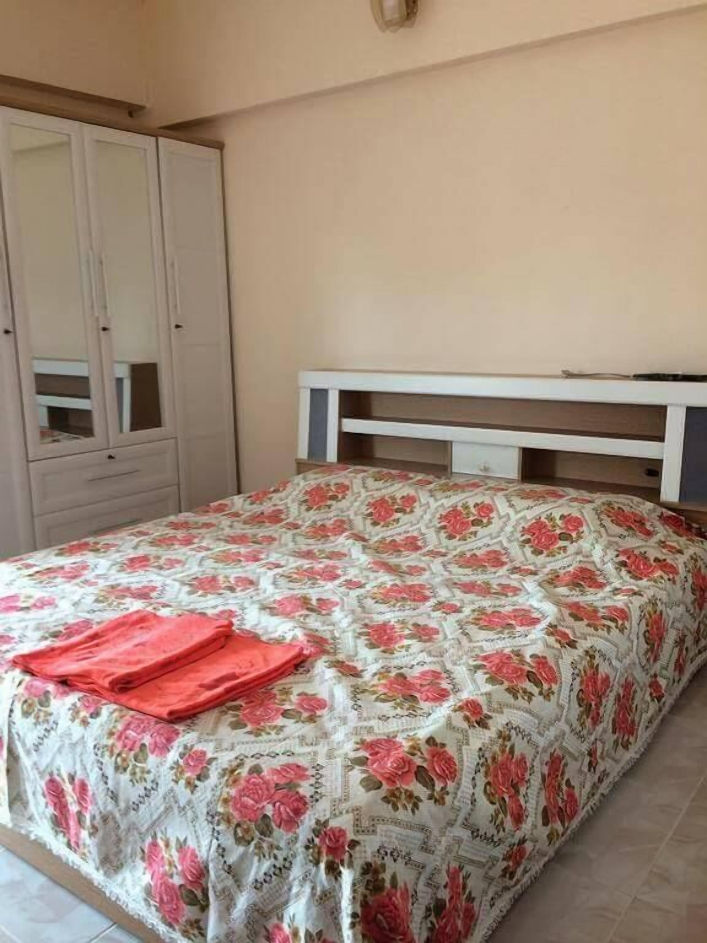 A bedroom with a bed, a wardrobe, and a nightstand.