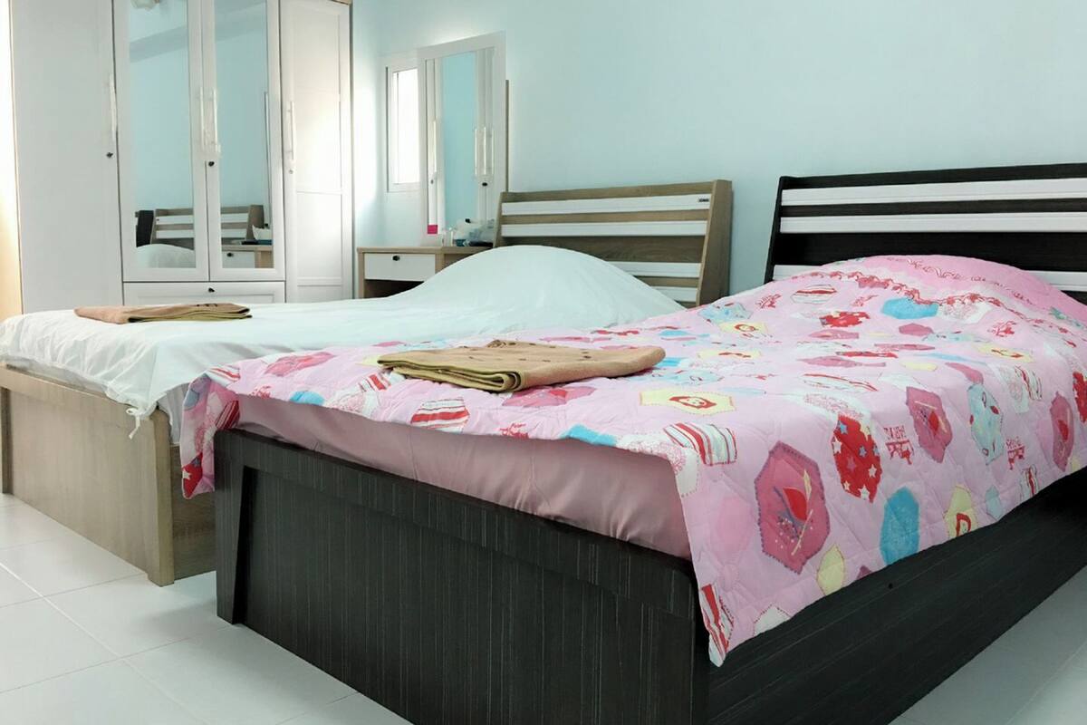Een slaapkamer met twee bedden, een kledingkast en een spiegel.