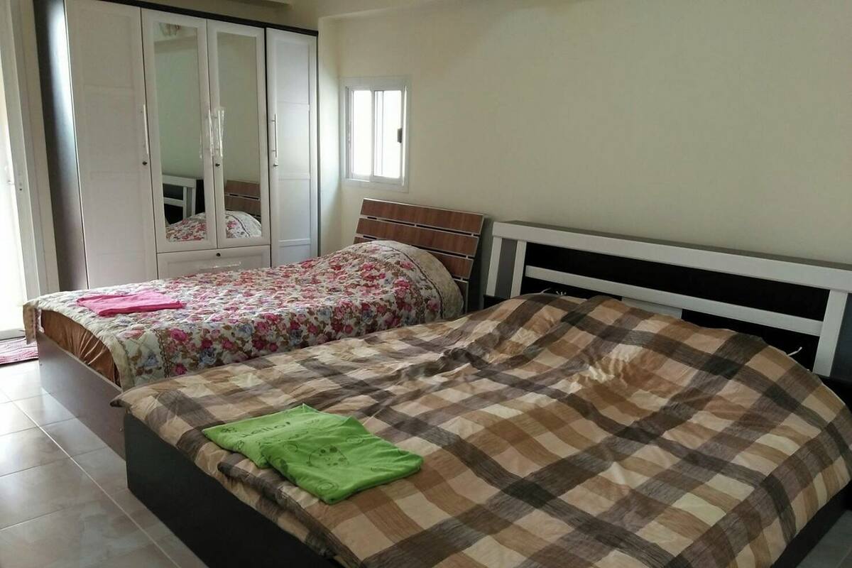 Een slaapkamer met twee bedden, een kledingkast en een raam.