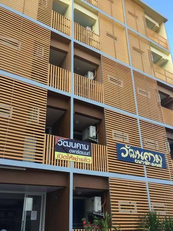Un immeuble à plusieurs étages doté d’une architecture moderne, caractérisé par des lambris en bois horizontaux sur la façade.