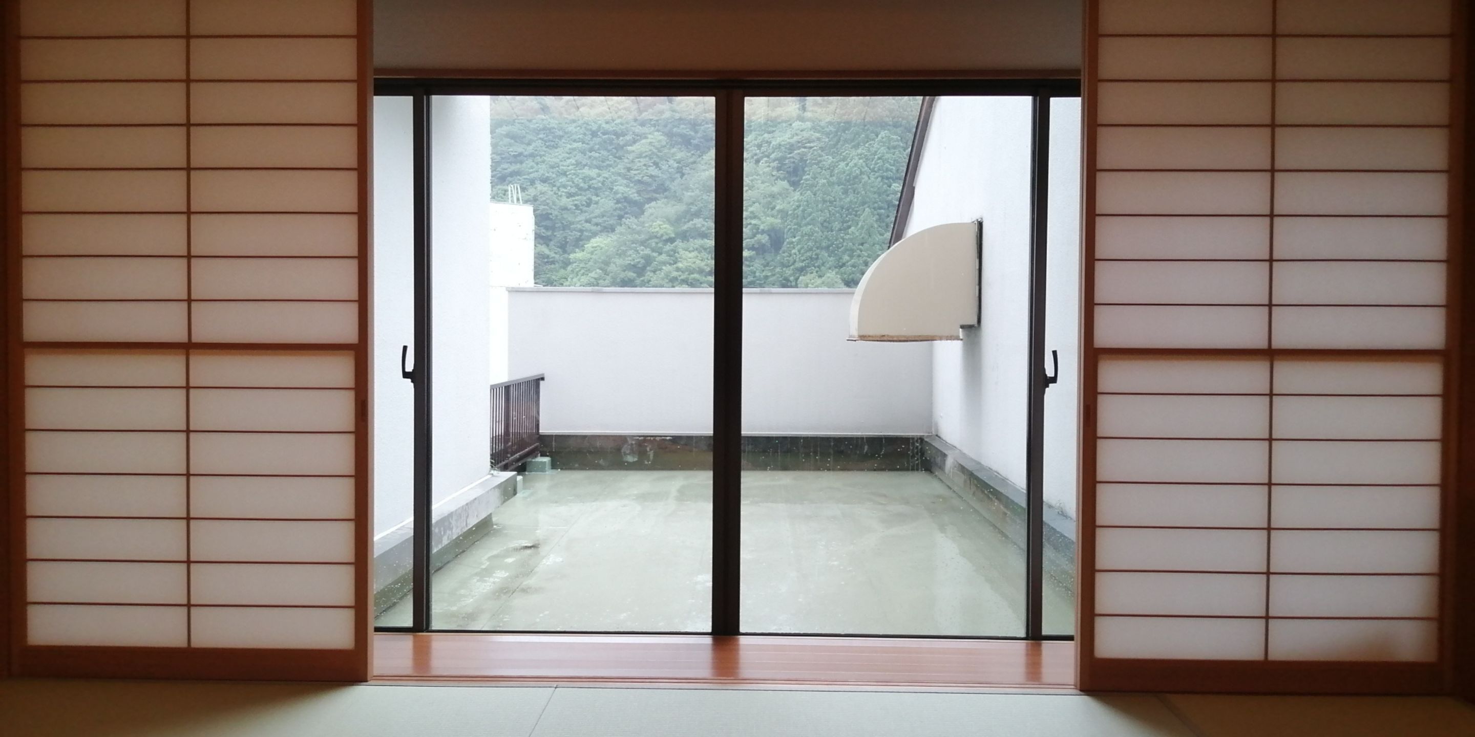A room with a sliding glass door leading to a balcony.