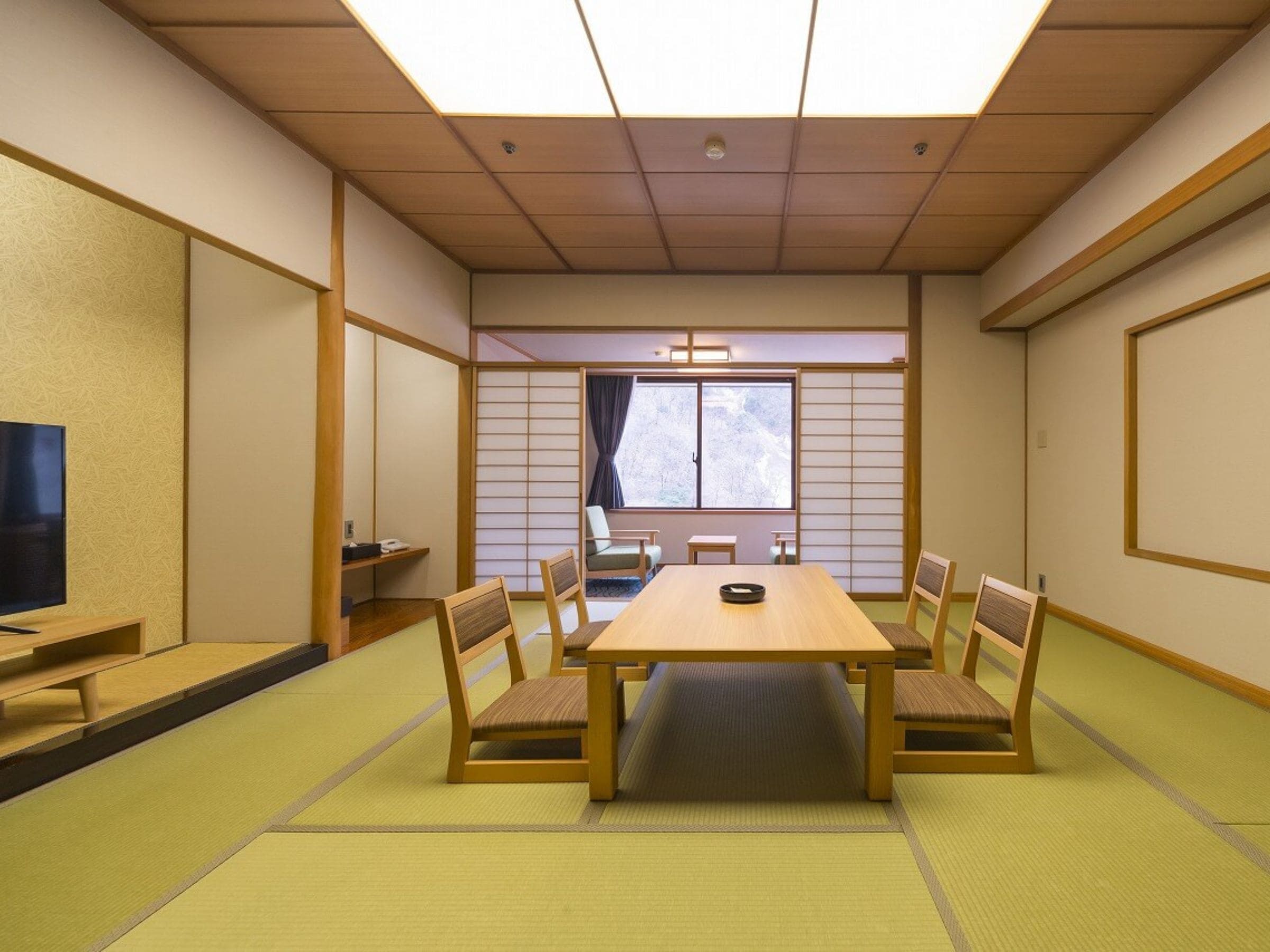A traditional Japanese-style room with tatami flooring, a low table, and shoji screens.