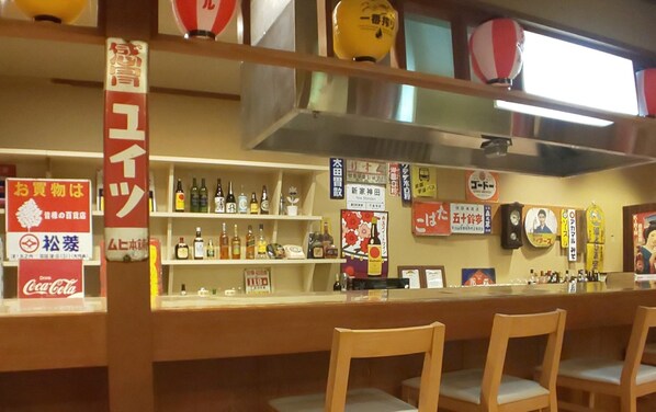 A bar area with shelves stocked with bottles, a Coca-Cola sign, and wooden chairs. - Kurobe Unazuki Onsen Yamanoha（ORIX HOTELS & RESORTS） (Kurobe)