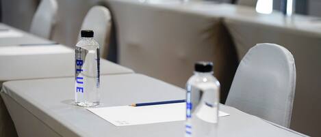 A conference table with water bottles labeled 'BLUE' and a notepad.