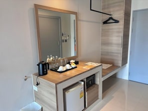 A modern bathroom with a wooden vanity, a mirror, a towel rack, and a small sink.