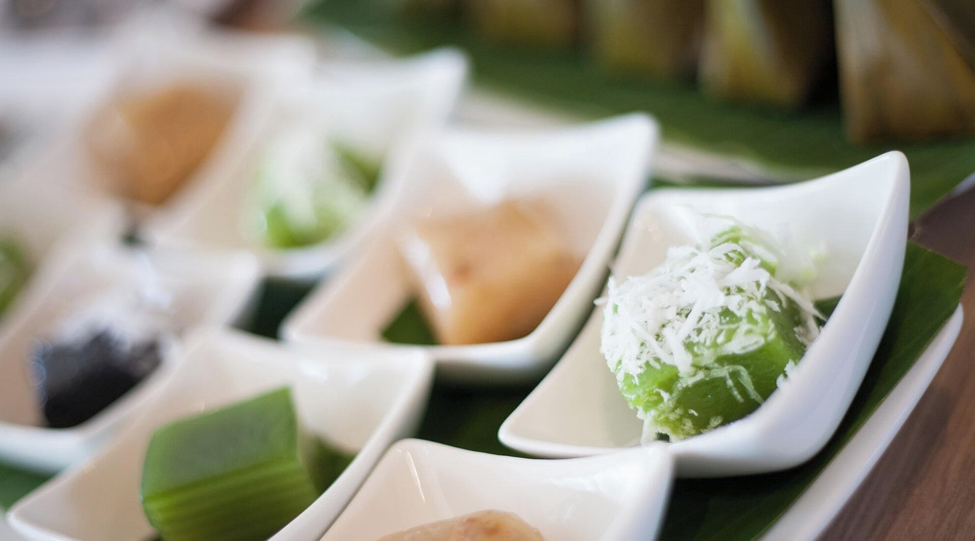 A series of dishes arranged on a table with a green leaf underneath each.