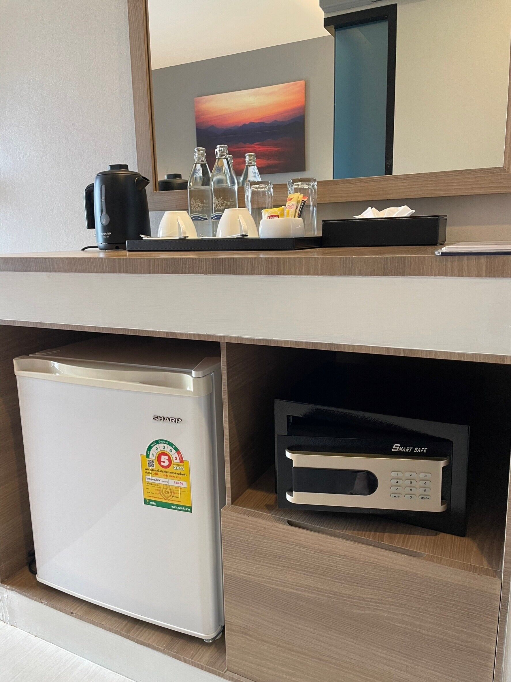 Une chambre d’hôtel équipée d’un petit réfrigérateur, d’une machine à café et d’un four à micro-ondes.