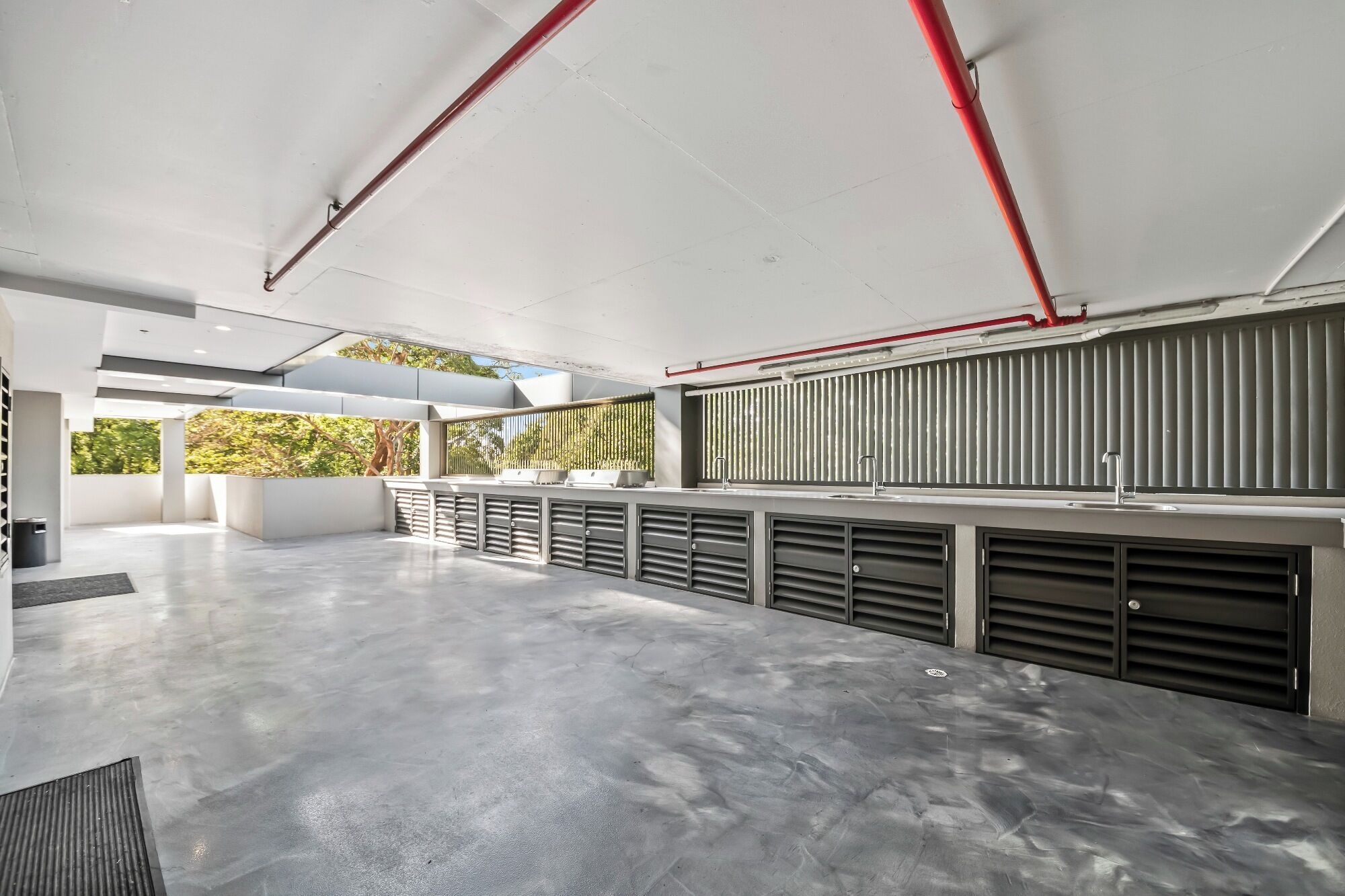 Una cocina amplia y moderna con una isla grande, electrodomésticos integrados y vistas a zonas verdes.