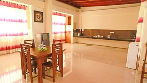 A spacious kitchen with a dining area, featuring a refrigerator, microwave, and a sink. - APL Apartments (Peliyagoda)