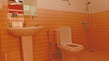 Une salle de bain avec un lavabo, des toilettes et une douche.