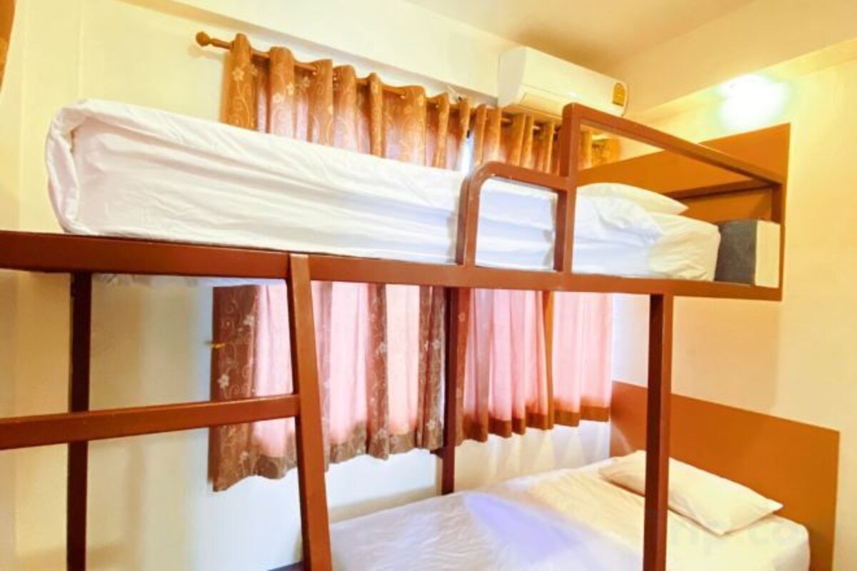 A bunk bed room with curtains and a light fixture.