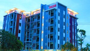 A multi-story hotel with a prominent 'The Pride' sign, multiple balconies, and a modern architectural design. - The Pride (Sam Phran)