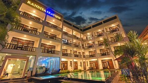 Ein mehrstöckiges Hotel mit Pool, Balkonen und einem Schild mit der Aufschrift "RANDIYA SEAVIEW".