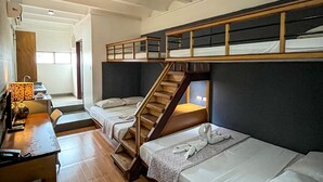 Un dormitorio con literas, un escritorio con lámpara y una escalera.
