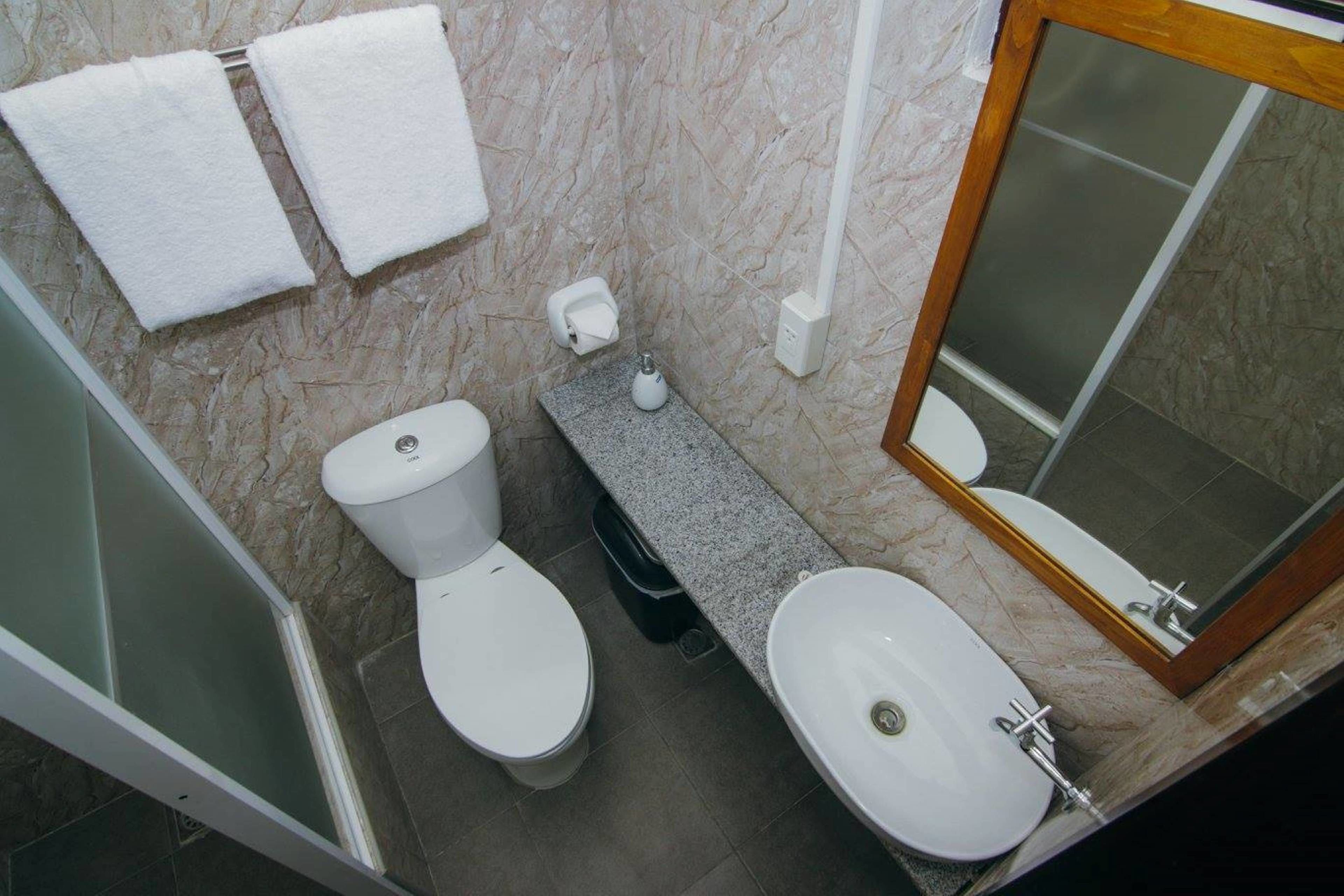 Kylpyhuoneessa on wc, bidee ja pesuallas. Seinällä on kaksi valkoista pyyhettä.