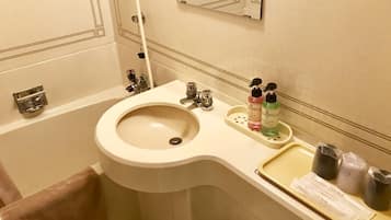 A bathroom with a sink, mirror, towel rack, and toiletries.