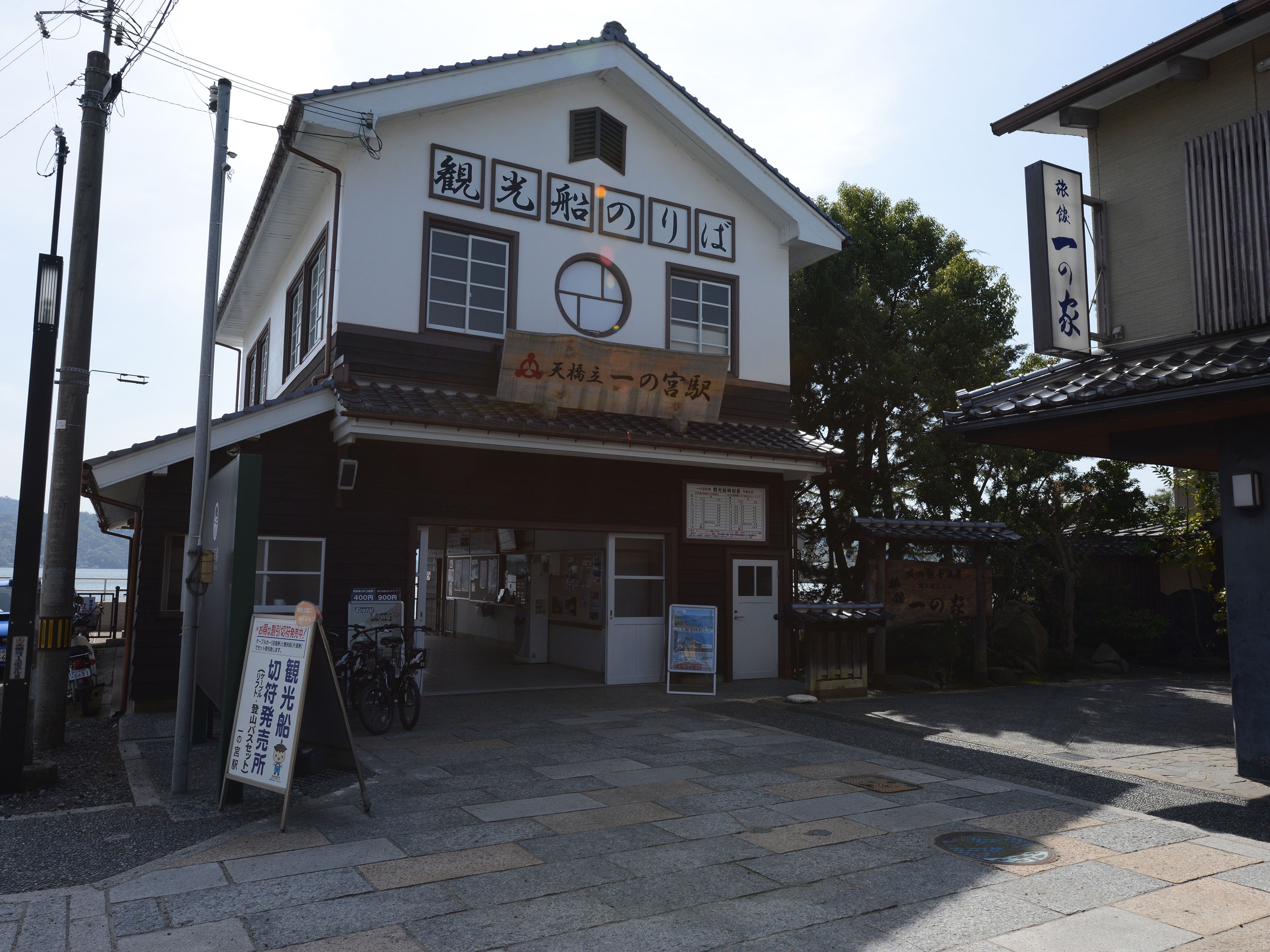 A traditional Japanese building with a signboard and a bicycle parked outside.